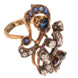 An Art Deco 18 ct yellow gold floral-shaped ring, set with a blue sapphire and diamonds, 8,5 g