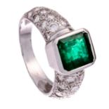 An 18ct white gold ring, set with a central dark green emerald and brilliant-cut diamonds, 7,4 g