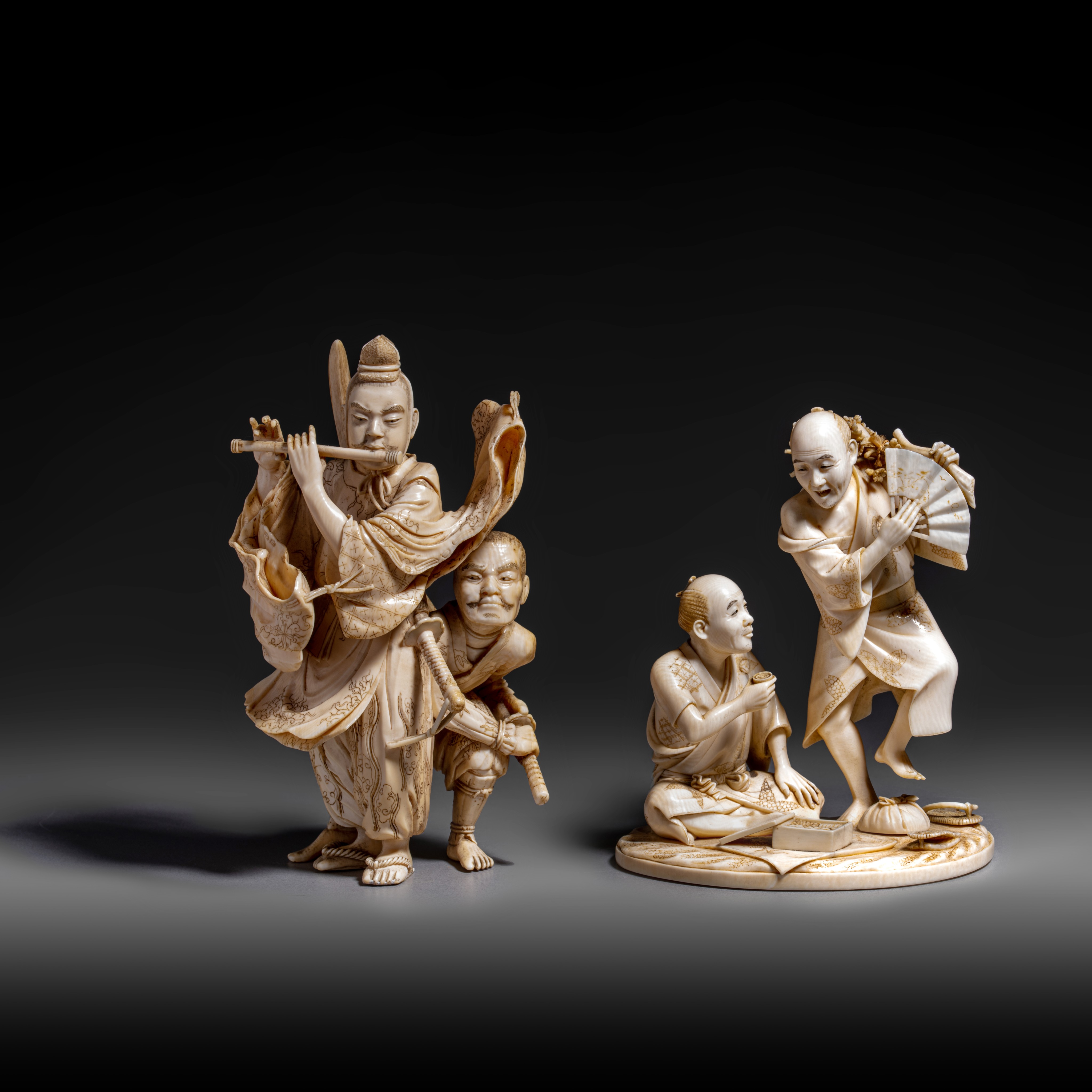 Two Japanese ivory okimono of a group of figures, H 11,2 cm - 13,3 cm, 195 - 233 g (+)