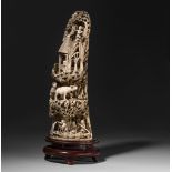 A sculpted ivory tusk with animated scenes on a mountain trail, late 19th C, H 41,5 cm, 2300g (with