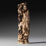 A Chinese walrus ivory Guanyin with a child standing on a Fo dog, H 26 cm - 749 g