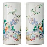 A pair of Chinese famille rose 'Playing boys' cylindrical vases, 19thC/Republic period, H 27,5 cm