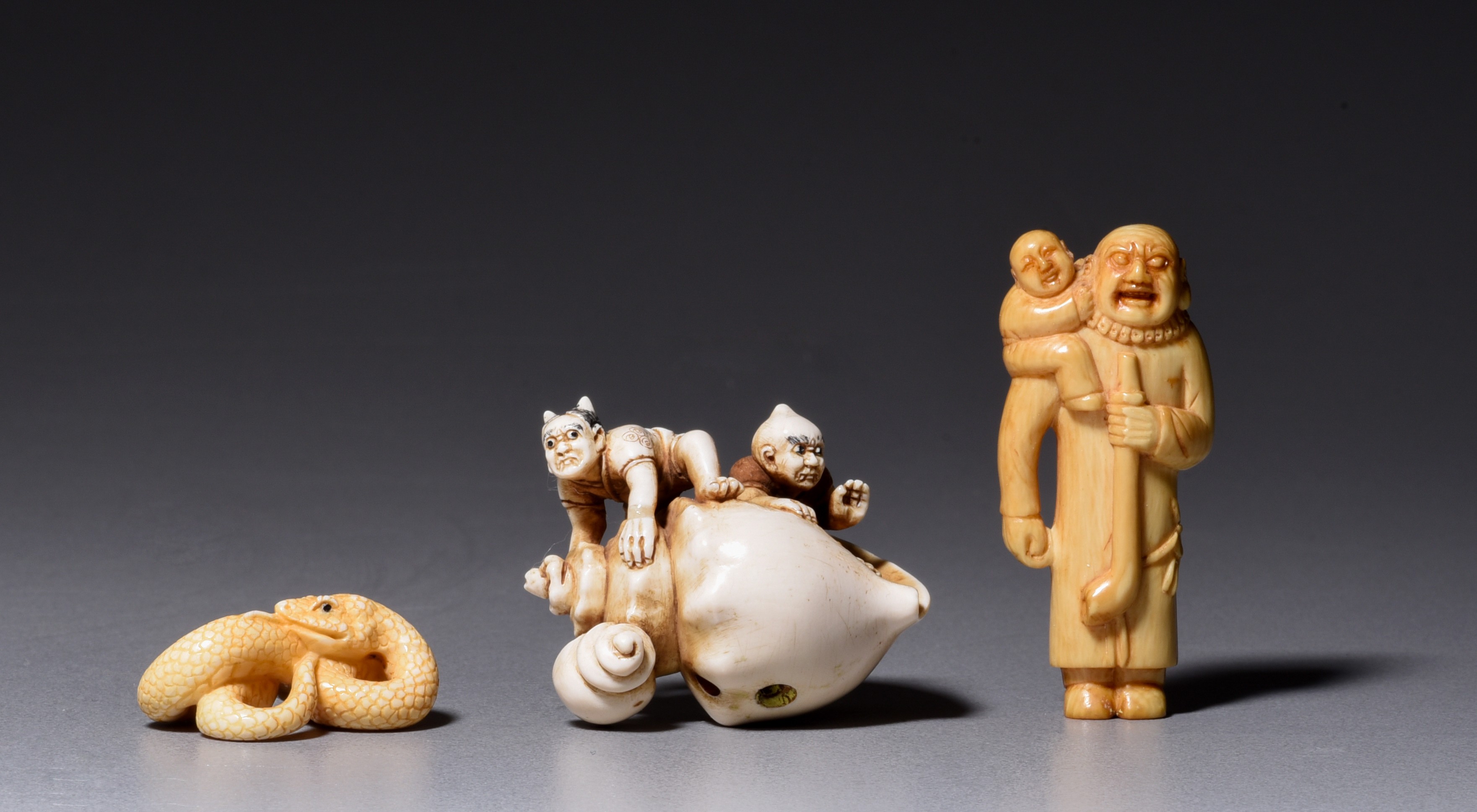 An ivory netsuke and two okimono, 19th/early 20thC, H 3,8 - 4,9 - 3 cm / 18g - 9g - 4g (+)