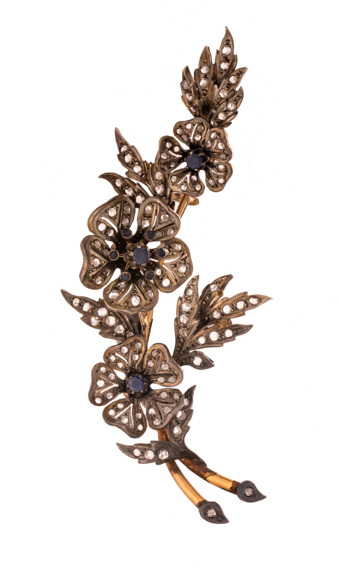 A silver and gold floral-shaped brooch, set with blue sapphires and diamonds, H 10,6 cm - 35 g
