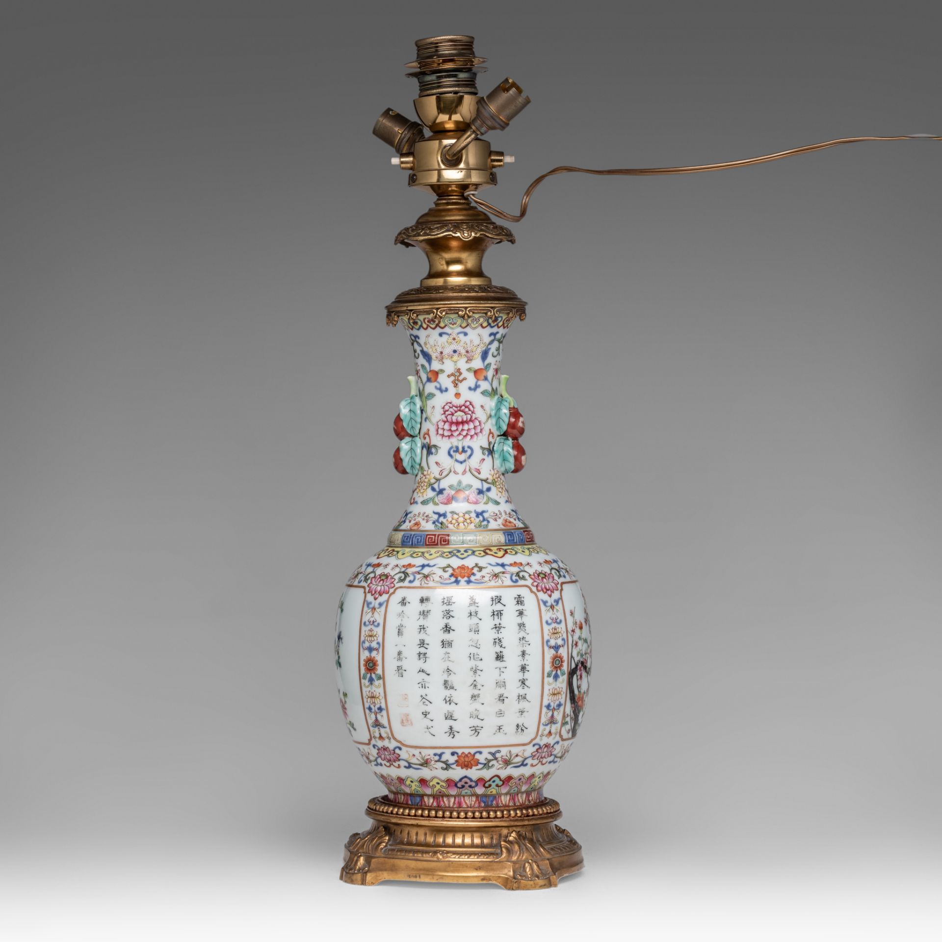 A Chinese famille rose floral decorated bottle vase, fixed with lamp mounts, with a Qianlong mark, T