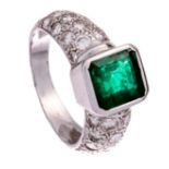 An 18ct white gold ring, set with a central dark green emerald and brilliant-cut diamonds, 7,4 g