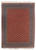 A large Persian woollen rug decorated with paisley motifs, 337/349 x 464 cm