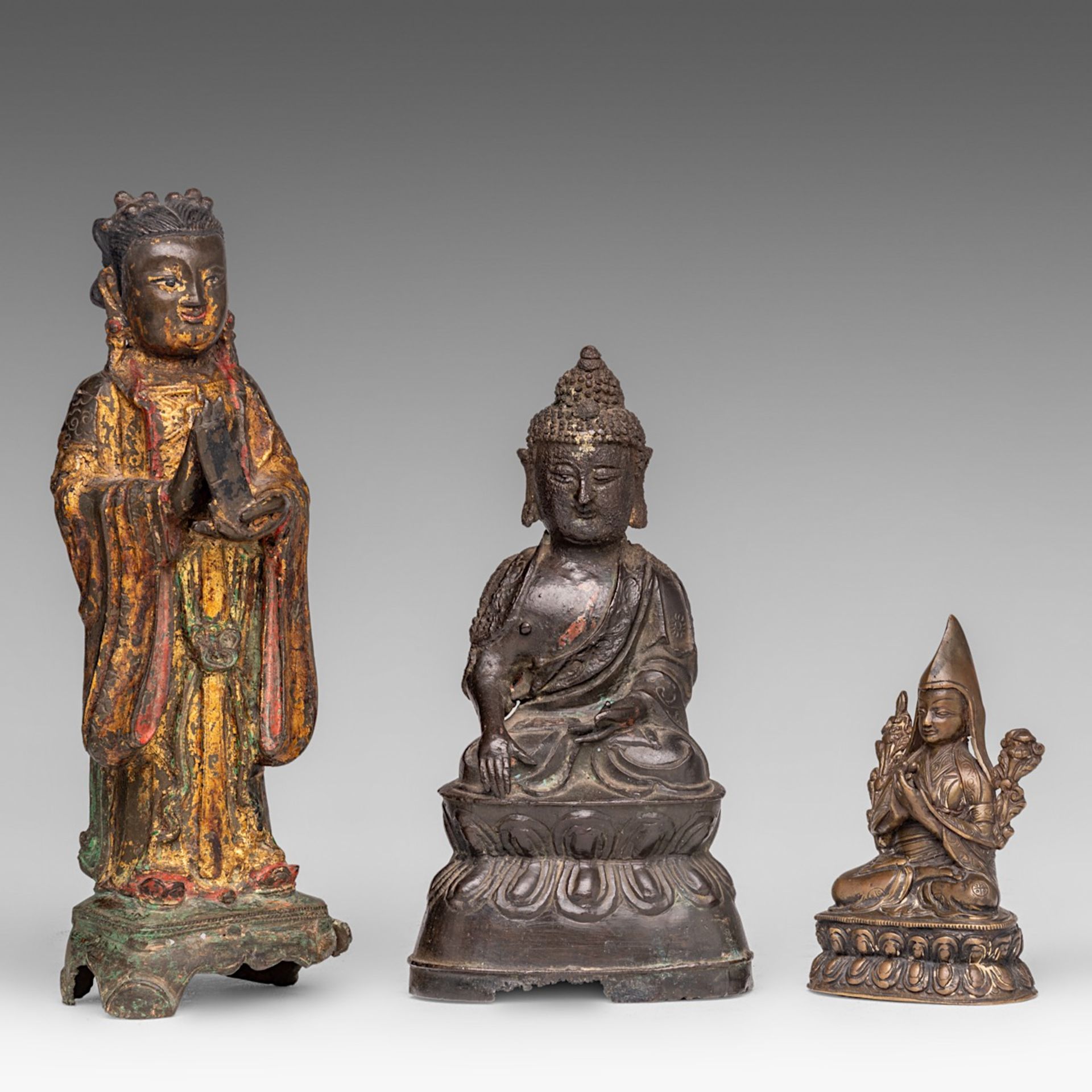 Three Chinese (lacquered) bronze figures of Buddha or an Immortal, Ming and 19thC, tallest H 26,5 cm
