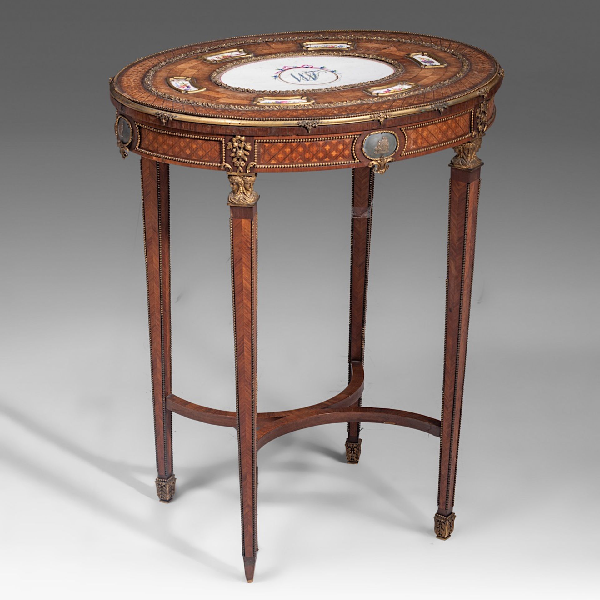 A fine Louis XVI style parquetry occasional table with Sevres porcelain plaques and gilt bronze moun
