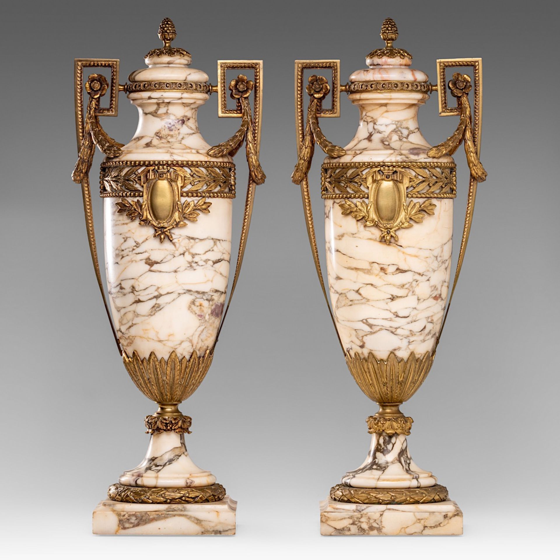 A pair of Neoclassical veined marble cassolettes with gilt brass mounts, H 61 cm