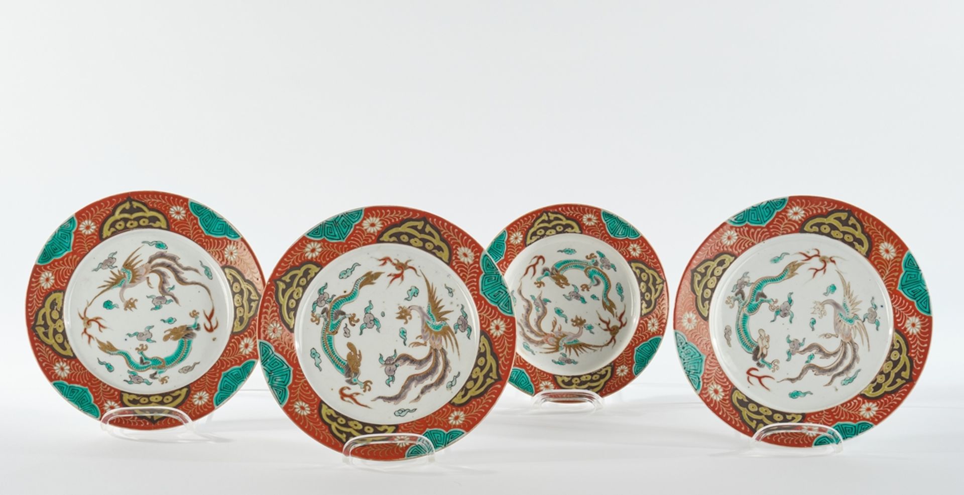 4 Teller, Japan, um 1900, Porzellan, farbiger Emaildekor, goldstaffiert, im Spiegel Drachen und Phö