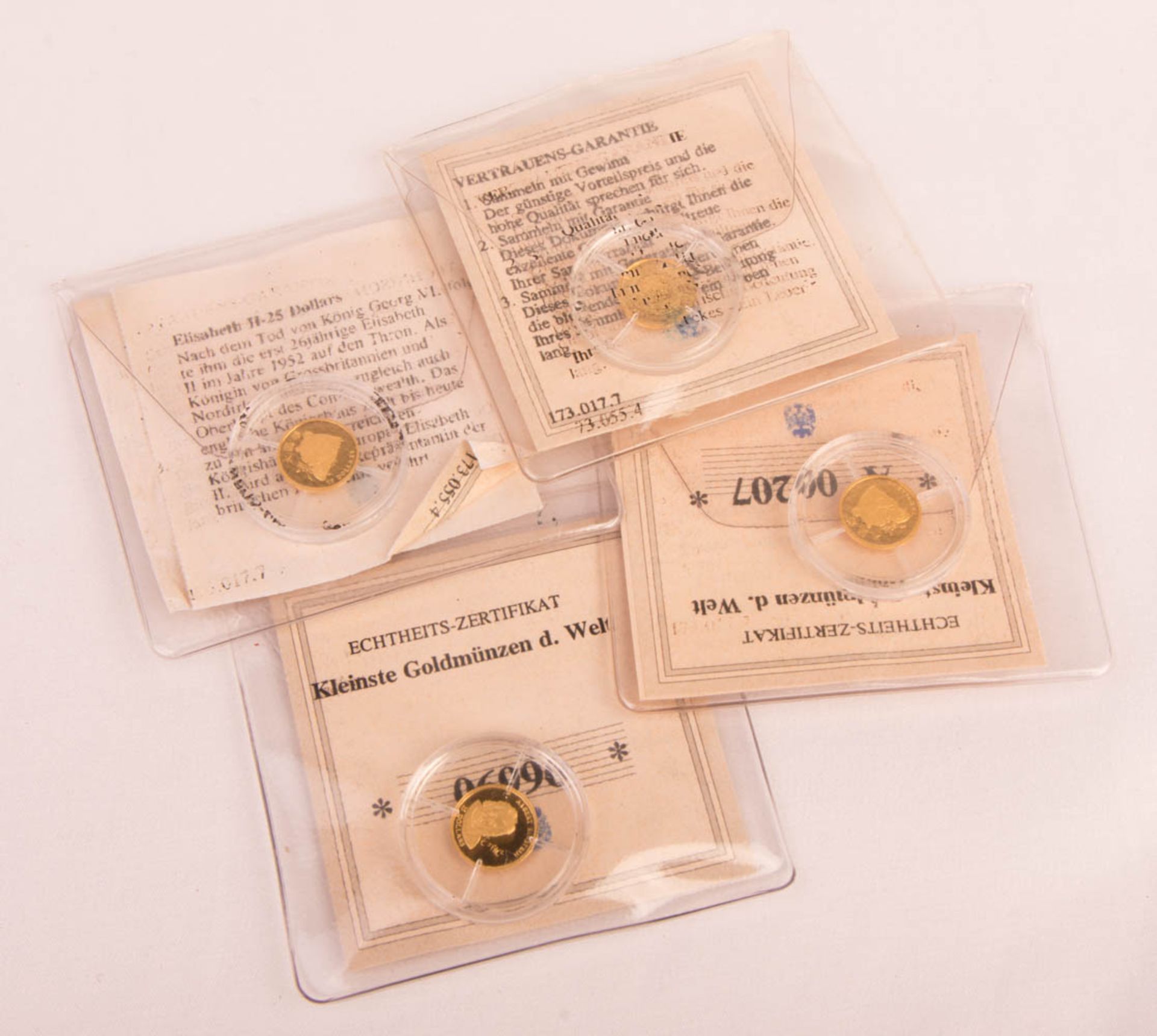 Four gold coins, 'Smallest gold coins in the world'.