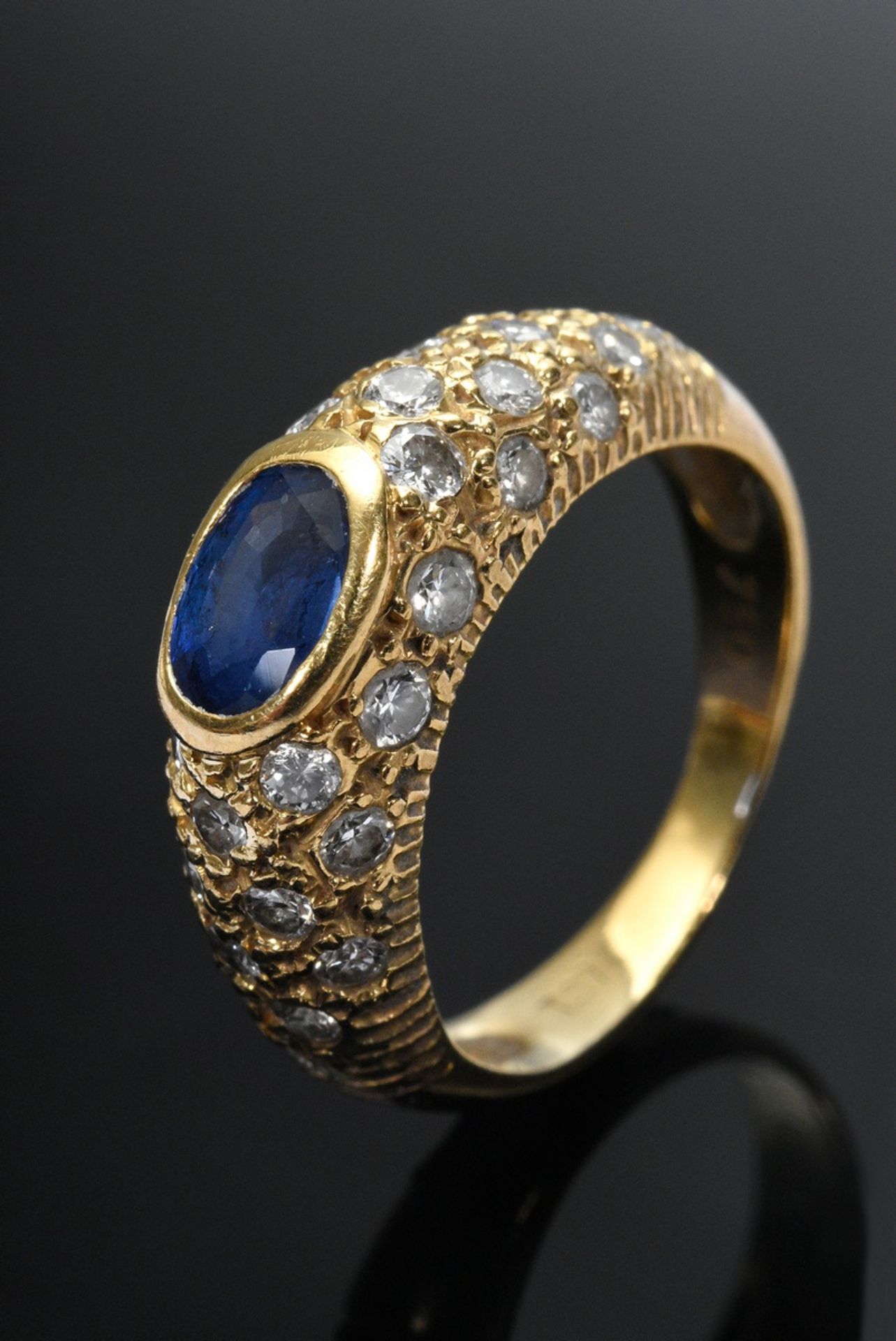 Fine yellow gold 750 band ring with sapphire in a pavé of diamonds (together approx. 0.60ct, VSI-SI