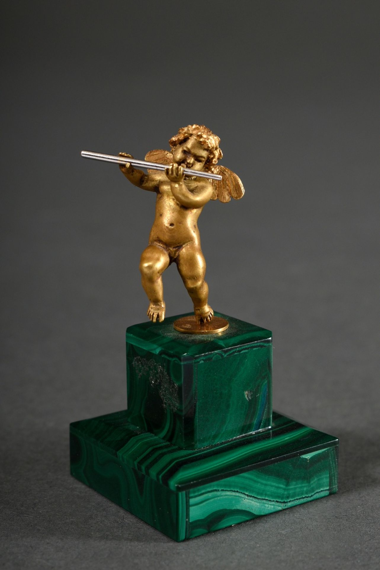 Yellow gold 750 miniature figure "Dancing Cupid with transverse flute" on eyelet on base covered wi