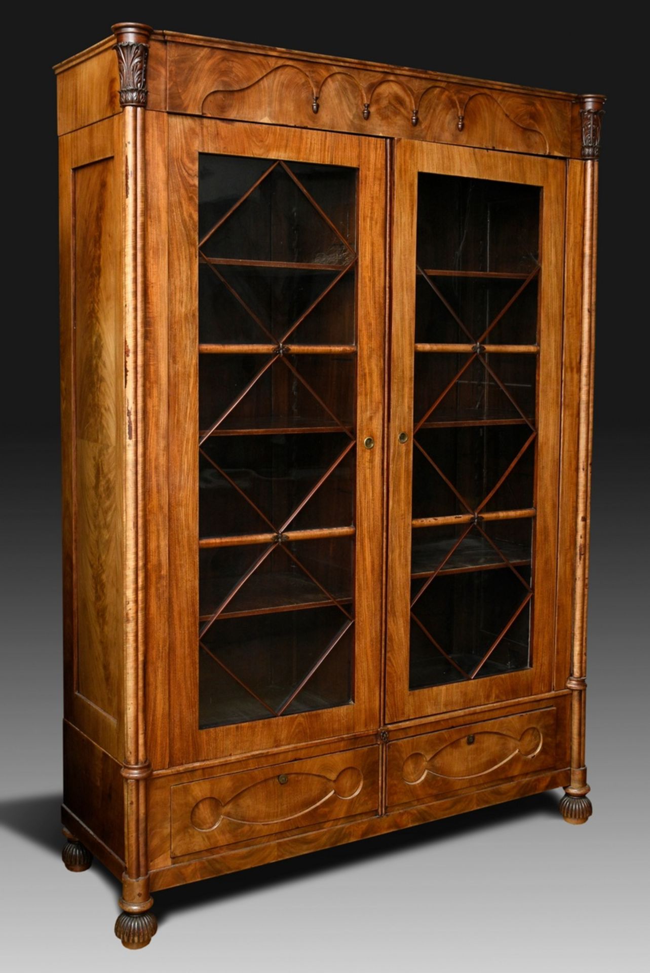 Biedermeier bookcase with gothic arches in the cornice and diamond bracing on the glazed doors betw
