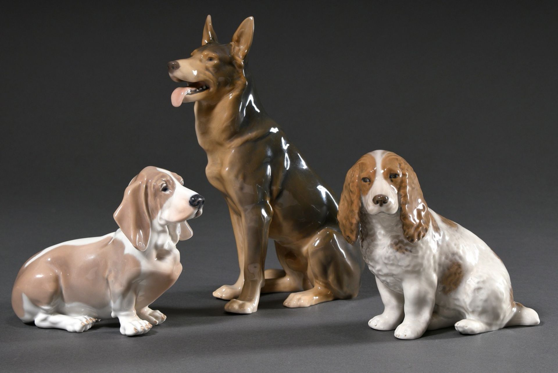 3 Diverse Porzellan Figuren "Basset", "Cocker Spaniel" und "Schäferhund" mit polychromer Unterglasu