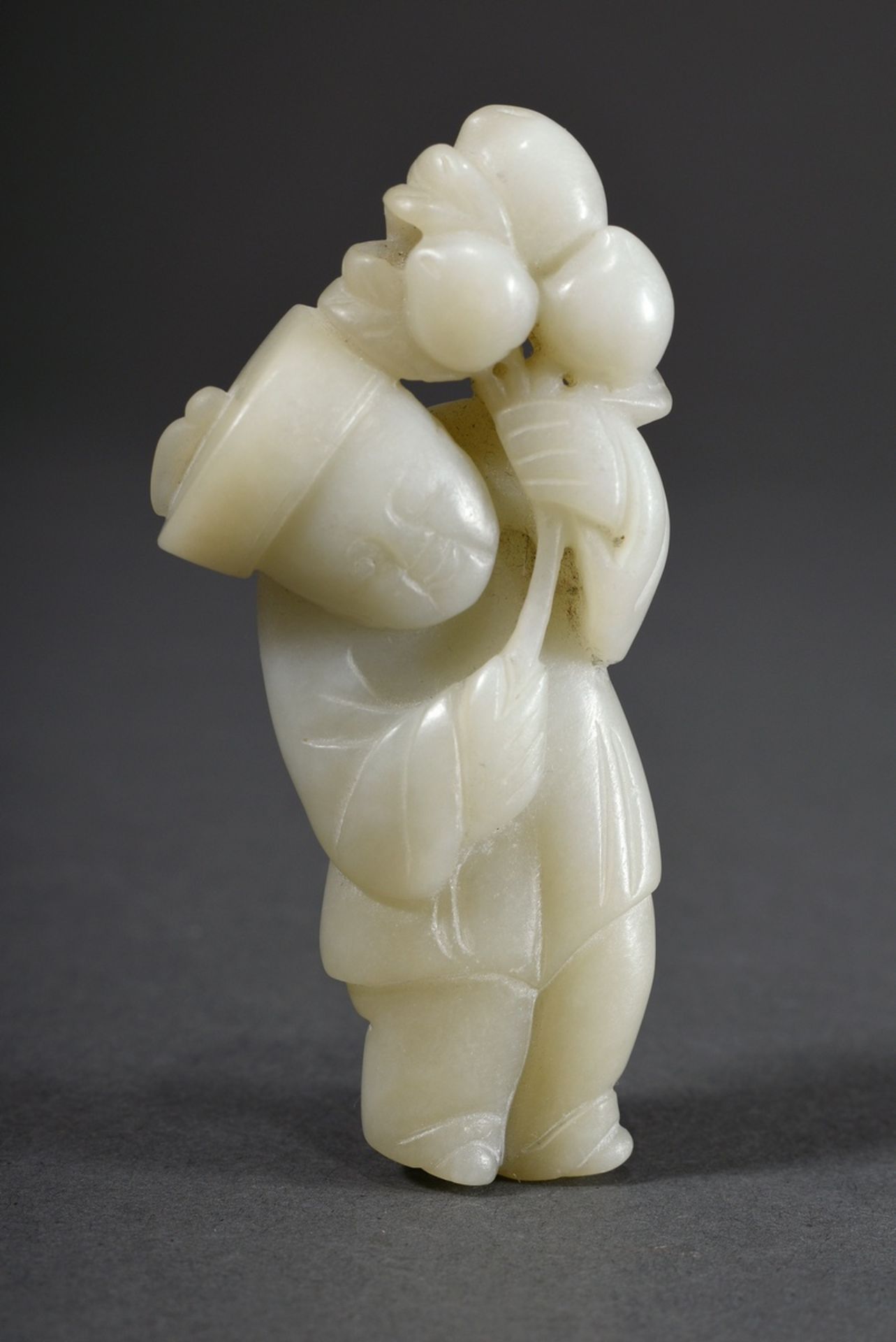 Celadon jade figure "Boy with peaches", China probably Qing Dynasty, on the back adhesive label "Sa