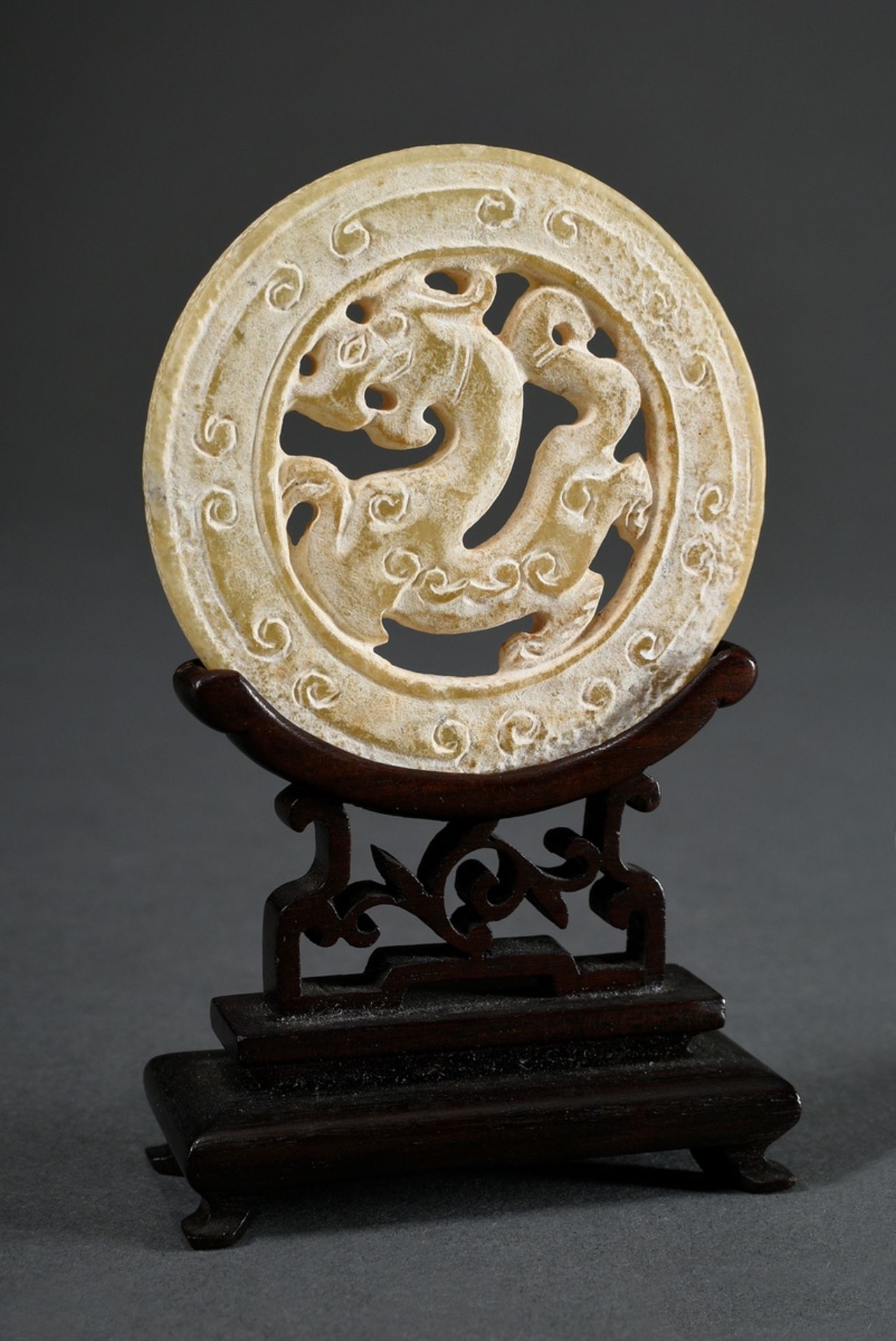 Huan jade disc with central mythical creature on a later Hongmu rosewood stand, surface mostly calc - Image 2 of 3