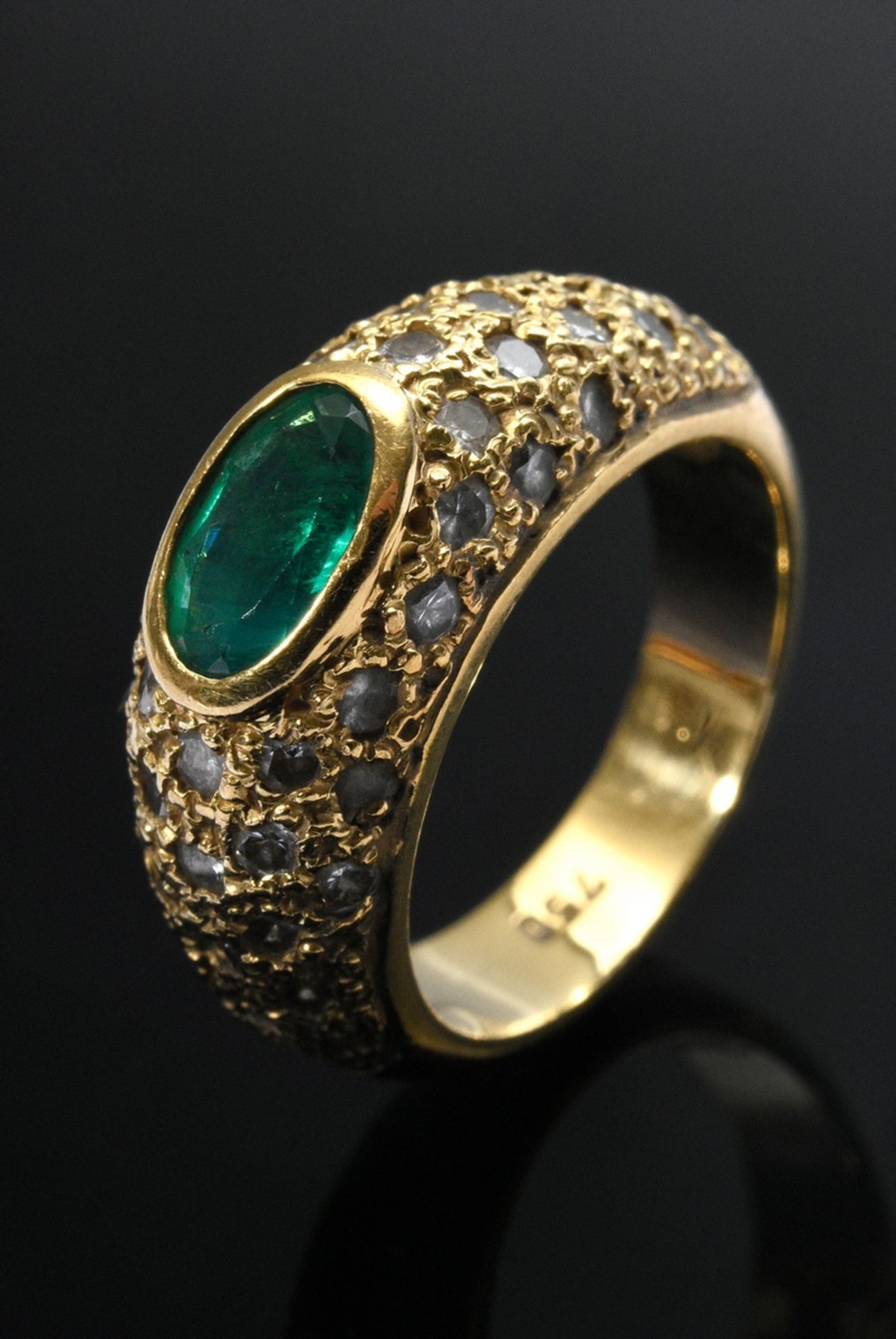 Fine yellow gold 750 band ring with emerald in a pavé of diamonds (together approx. 0.65ct, VSI-SI/