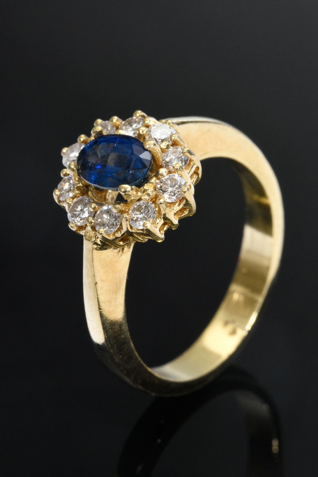 Gelbgold 750 Entourage Ring mit facettiertem Saphir (ca. 0.55ct) in Brillantlünette (zus. ca. 0.35c