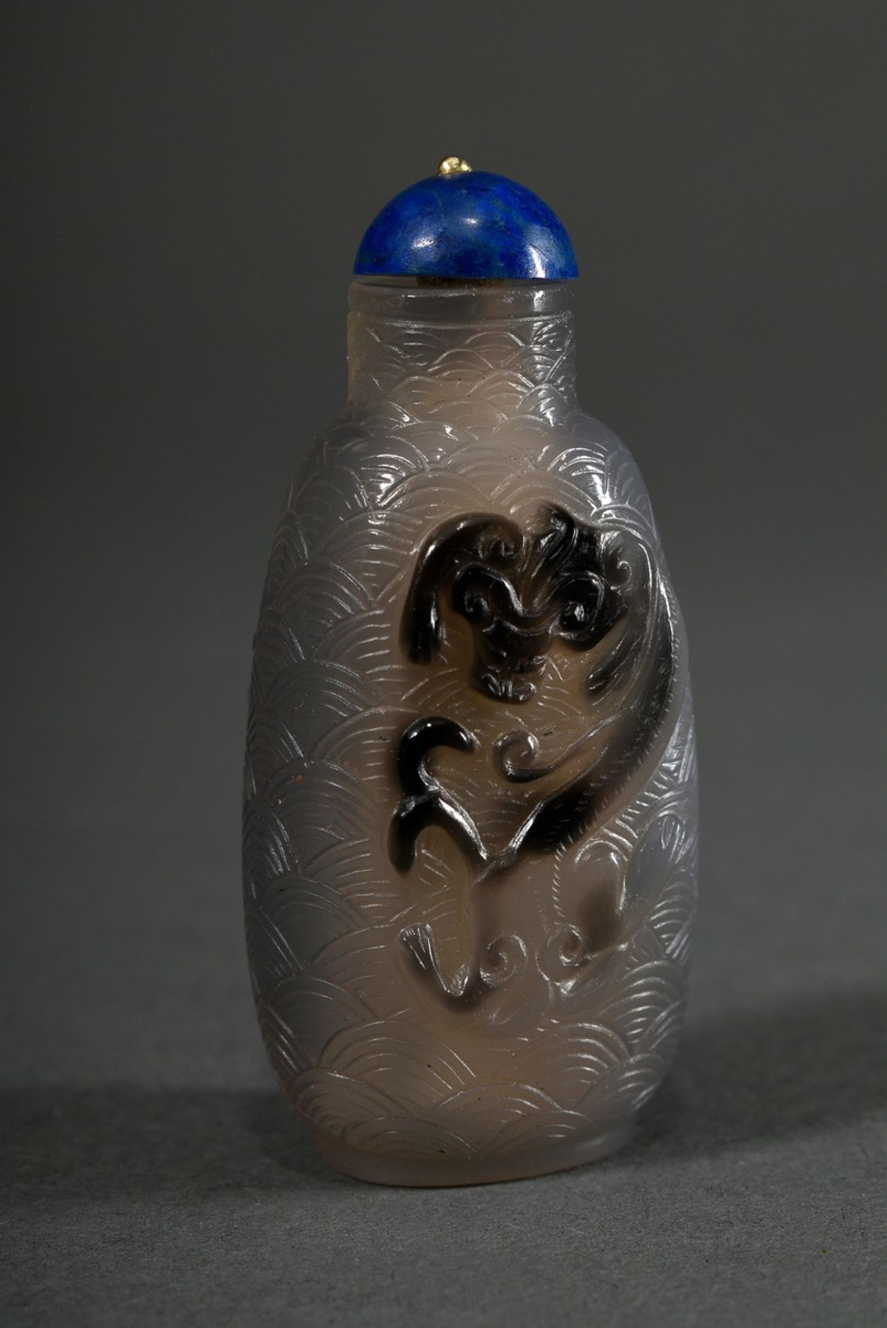 Very fine two-coloured jade snuffbottle "Chilongs" in high relief on deep cut wave decoration, stop