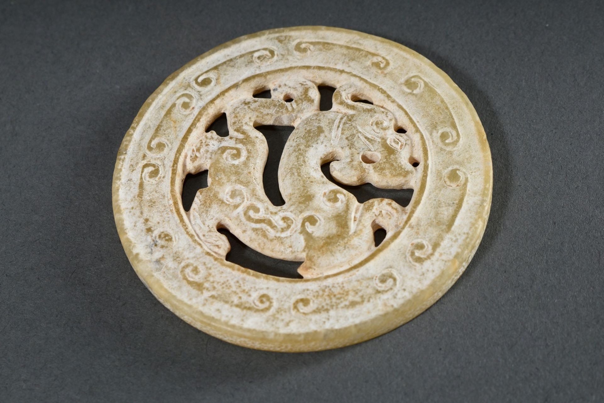 Huan jade disc with central mythical creature on a later Hongmu rosewood stand, surface mostly calc - Image 3 of 3