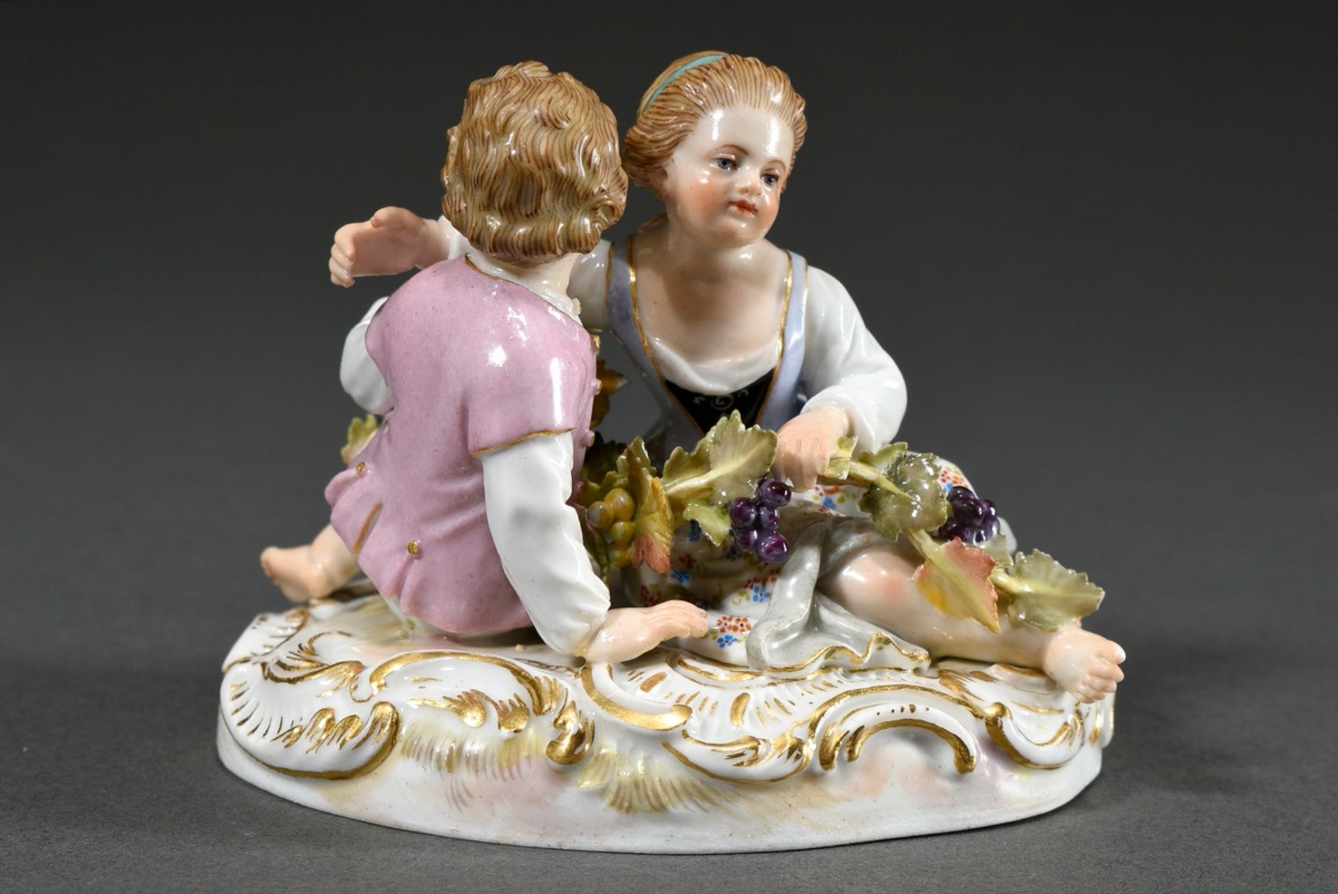 Small Meissen group "Two Children with Grapes", a boy and a girl sitting on an oval rocaille base f