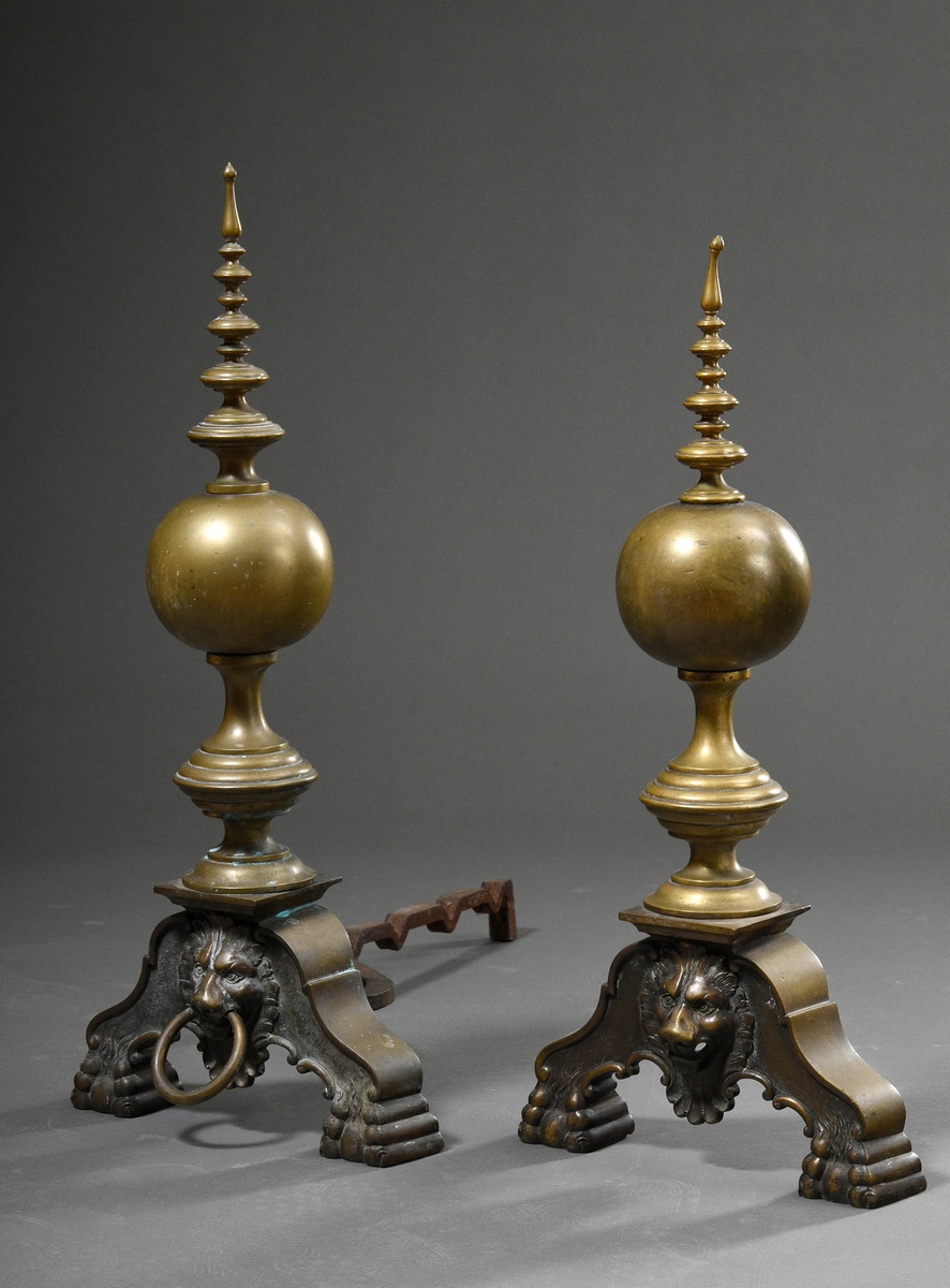 Pair of monumental cast brass andirons on curved feet with lion mascarons and tapering balusters ov