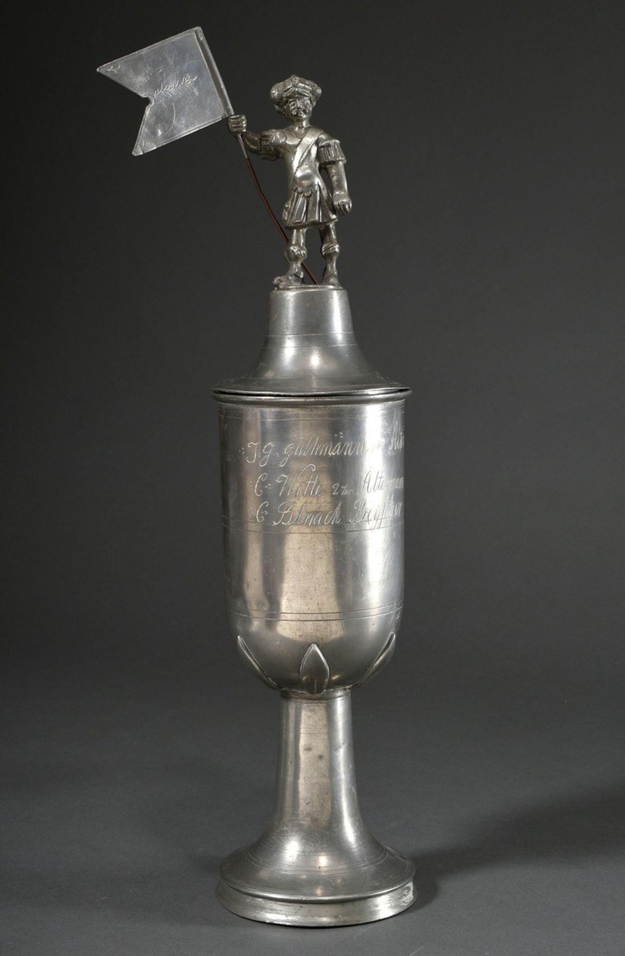 Large pewter guild cup "Willkomm" with plastic lid crowning "flag bearer", engraved inscription "Es