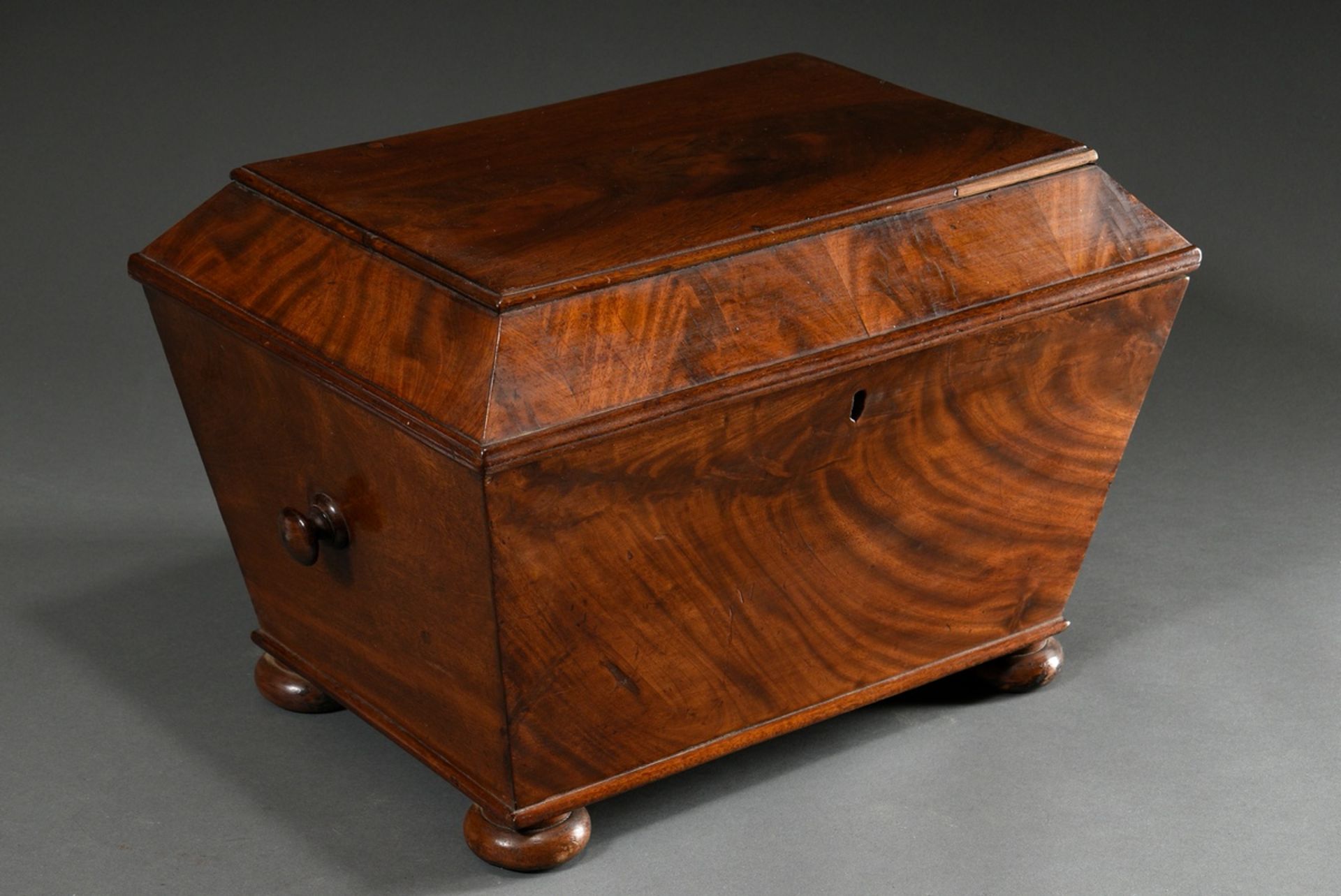 Large mahogany box in the shape of a sarcophagus with carrying knobs on the sides, compartmentalisa