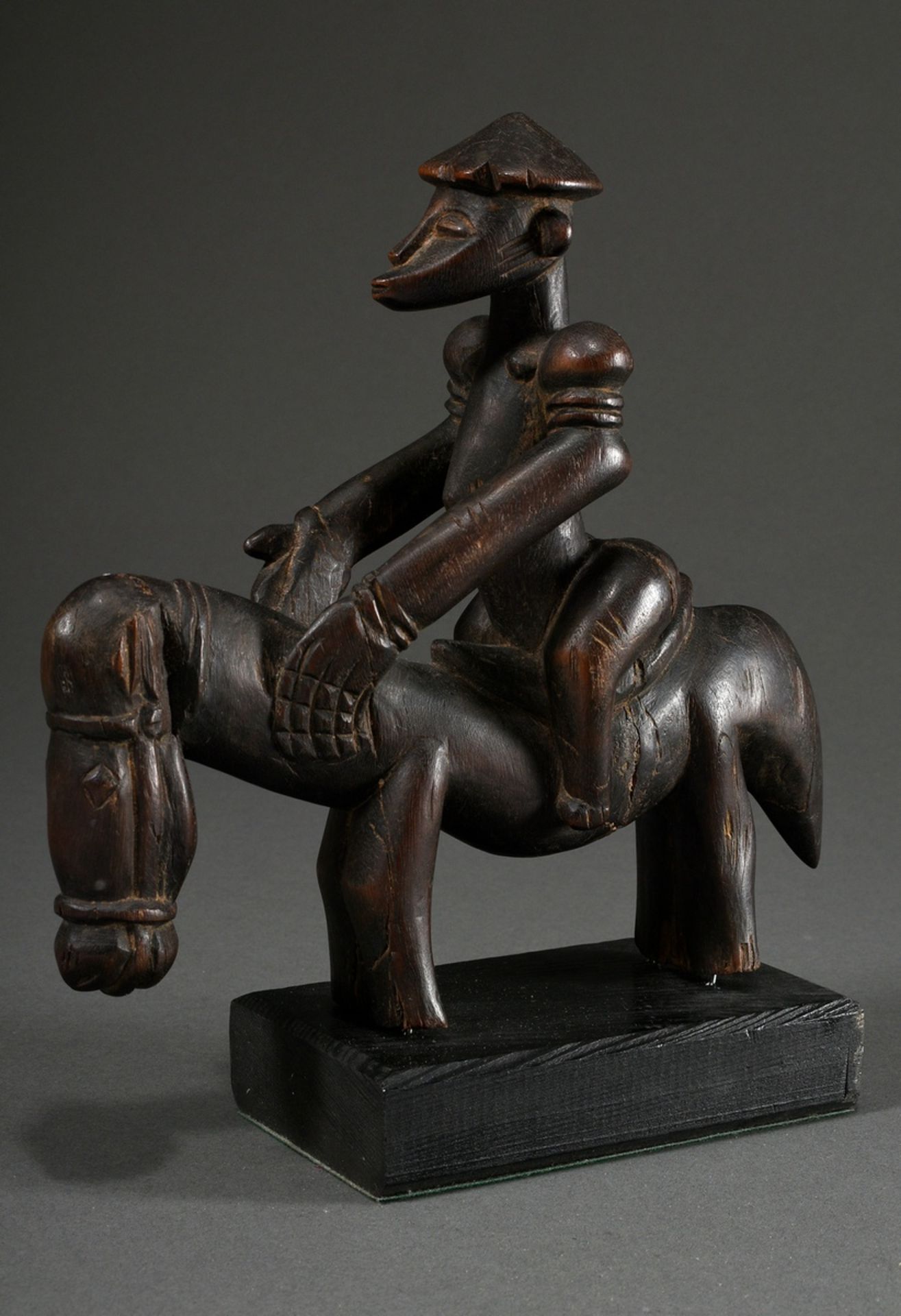 Equestrian statuette of a muscular figure with pointed headgear and scarification marks on the body