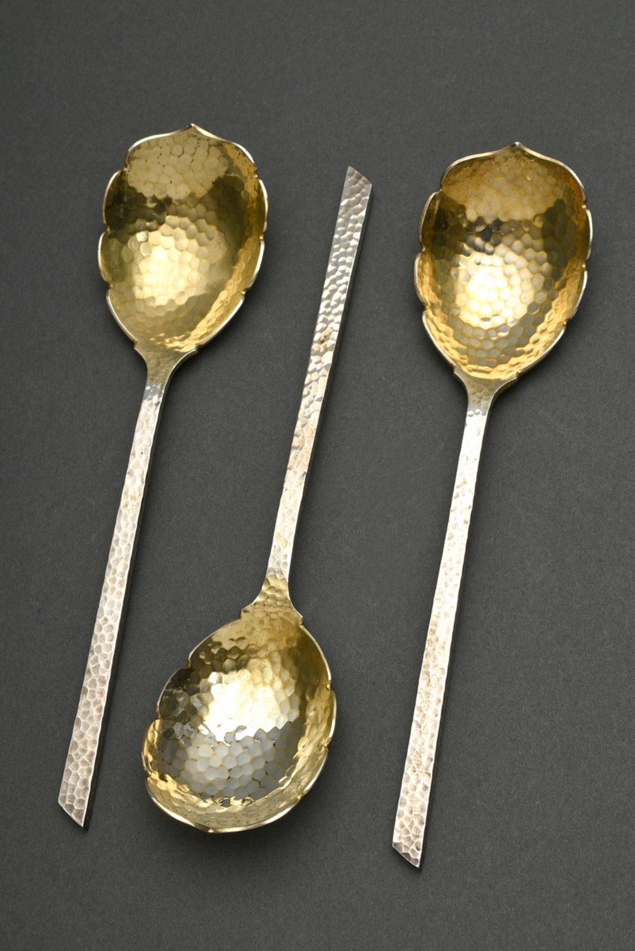 3 Martellated serving spoons with gilded floral lobe and angular handle, MM: Otto Schneider/Berlin,