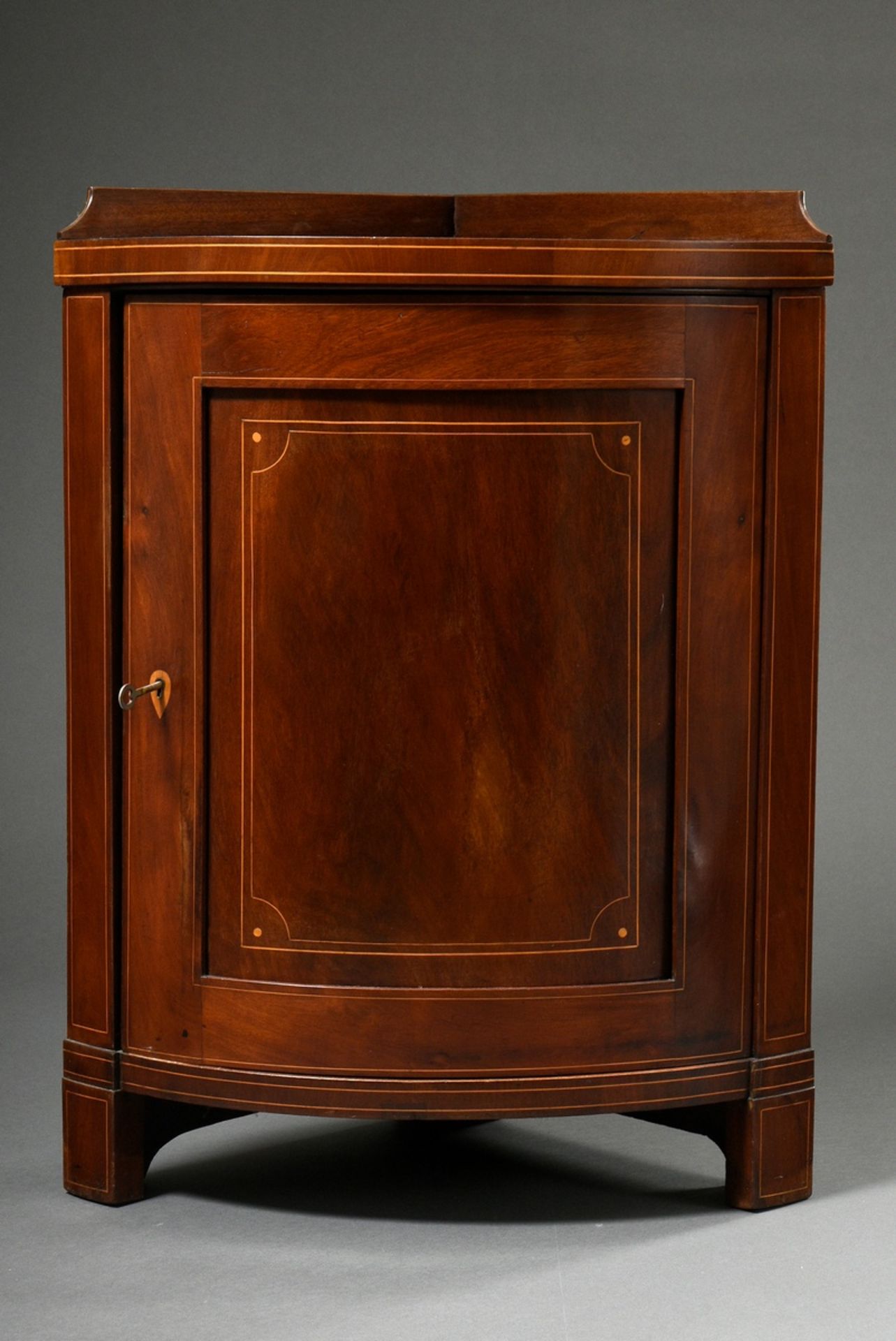 Small corner cupboard with rounded front, mahogany veneer with light inlays, England c. 1900, 82x62