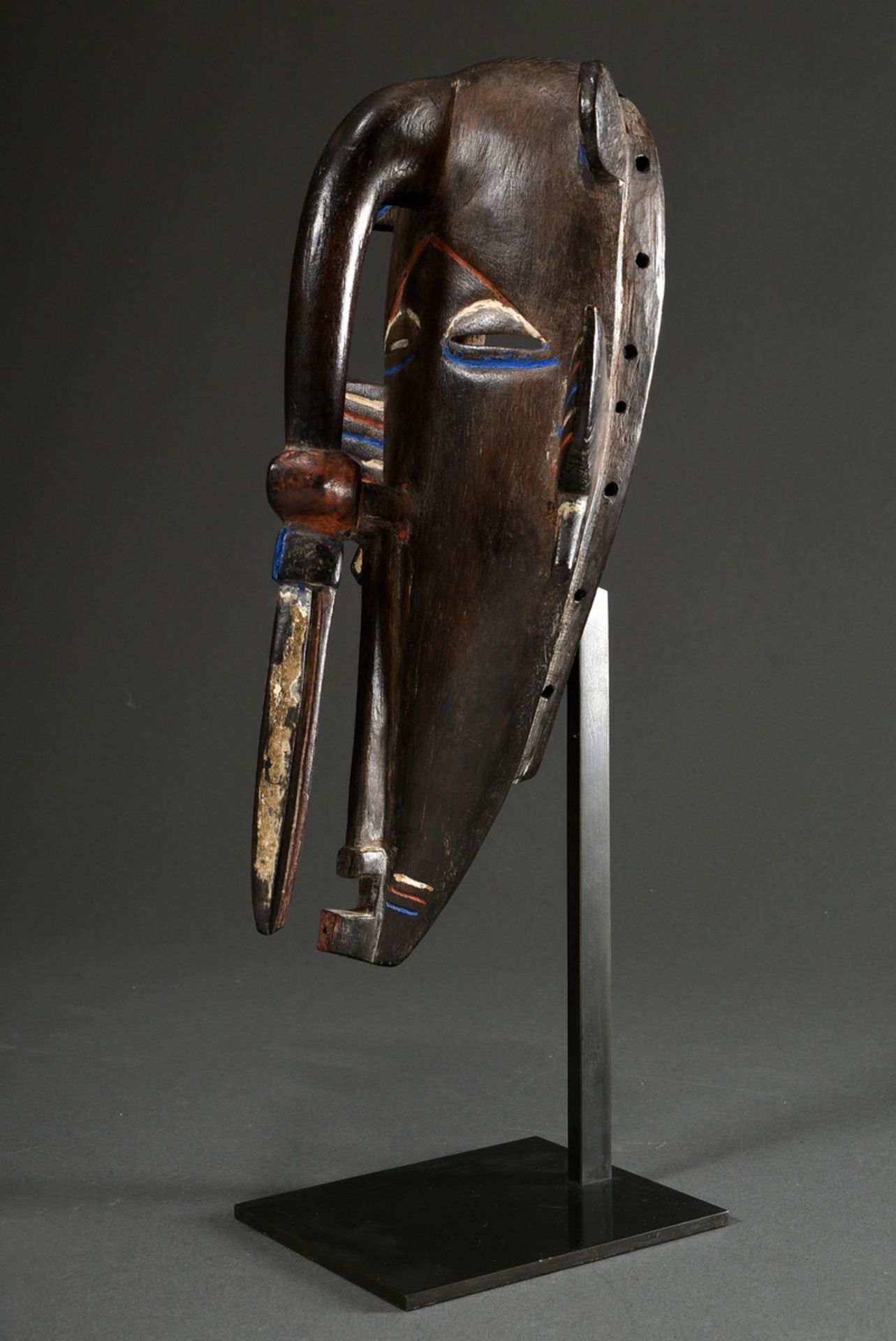 Senufo mask with tapering chin and beak-shaped forehead, carved wood and partially painted blue/whi