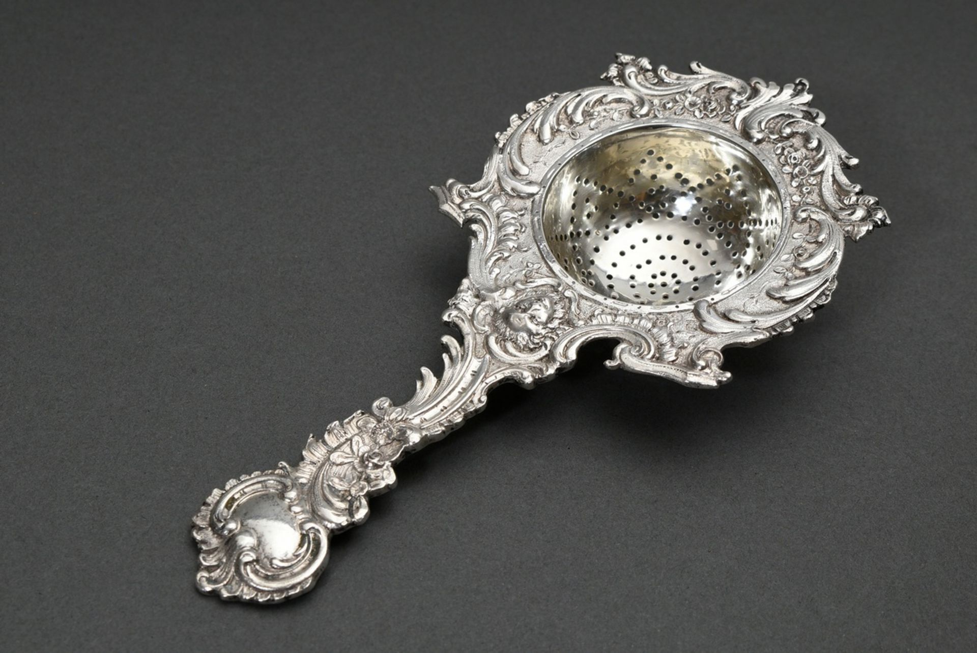 Historism tea strainer in neo-rococo style with mascaron and rocaille decoration, hallmarked silver