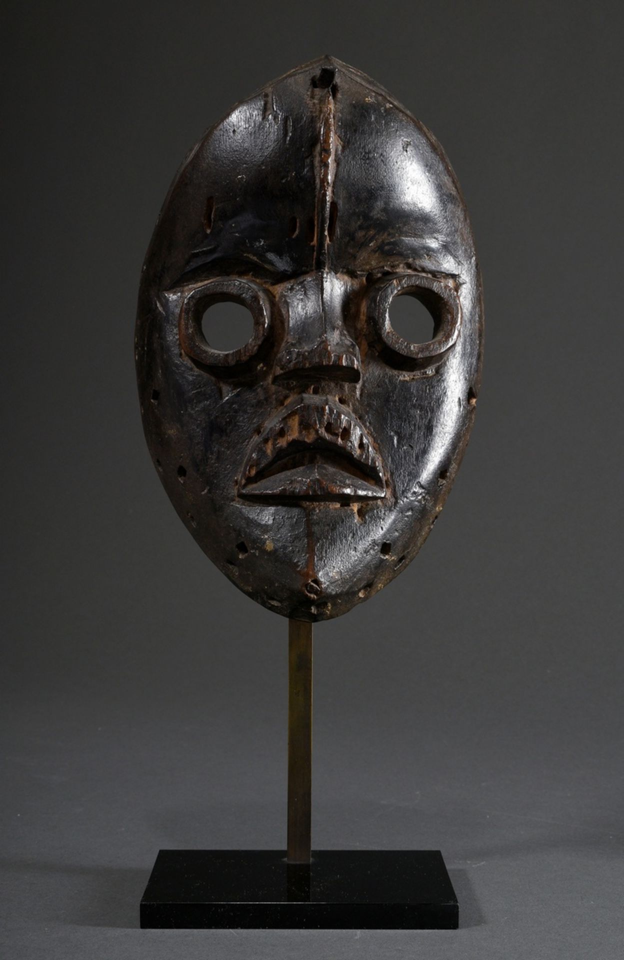 Dan mask with round eyes and iron nail above vertical forehead bulge, carved wood and dark patina, 