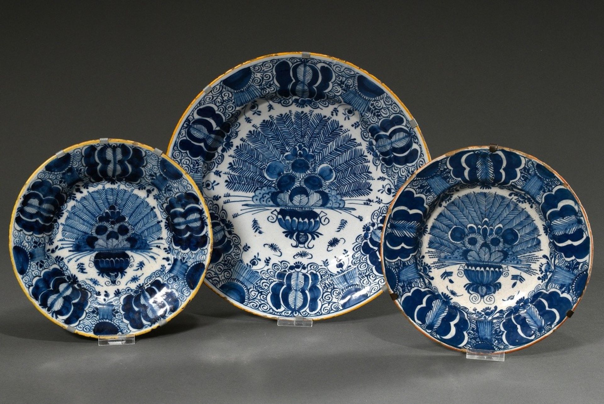 3 Various Delft "Peacock plates" with blue painting decoration and yellow rim: 1x De verguldte Bloe