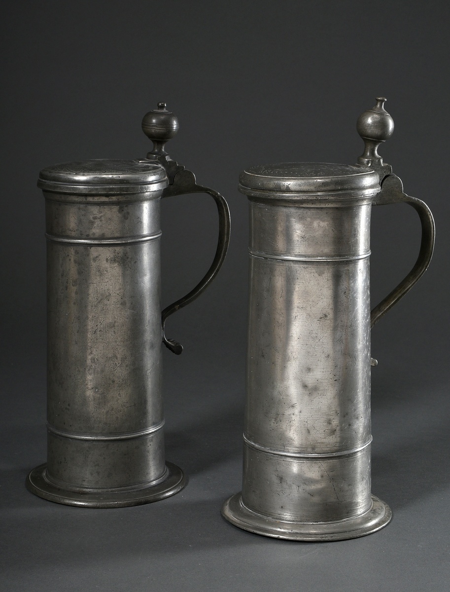 2 Diverse Lübeck pewter pillar jugs or tap seats with spherical thumb rest, ornamental relief on th