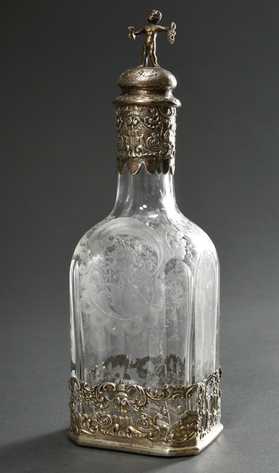 Small angular rum carafe with floral cut glass body in ornamental silver mounting and plastic cork 