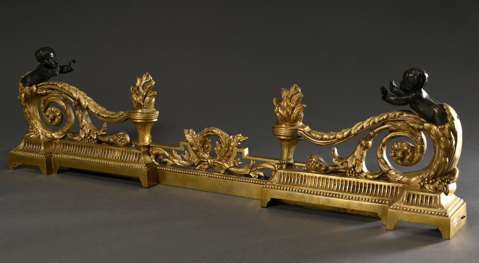 French brass mantelpiece in Louis XVI style with leaf volutes, flame vases and laurel wreath motif,