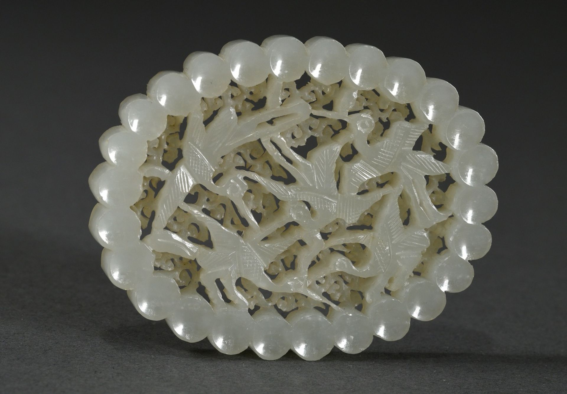 Light oval jade plaque "Cranes", in front of ornamental background in two planes, rim with concave 