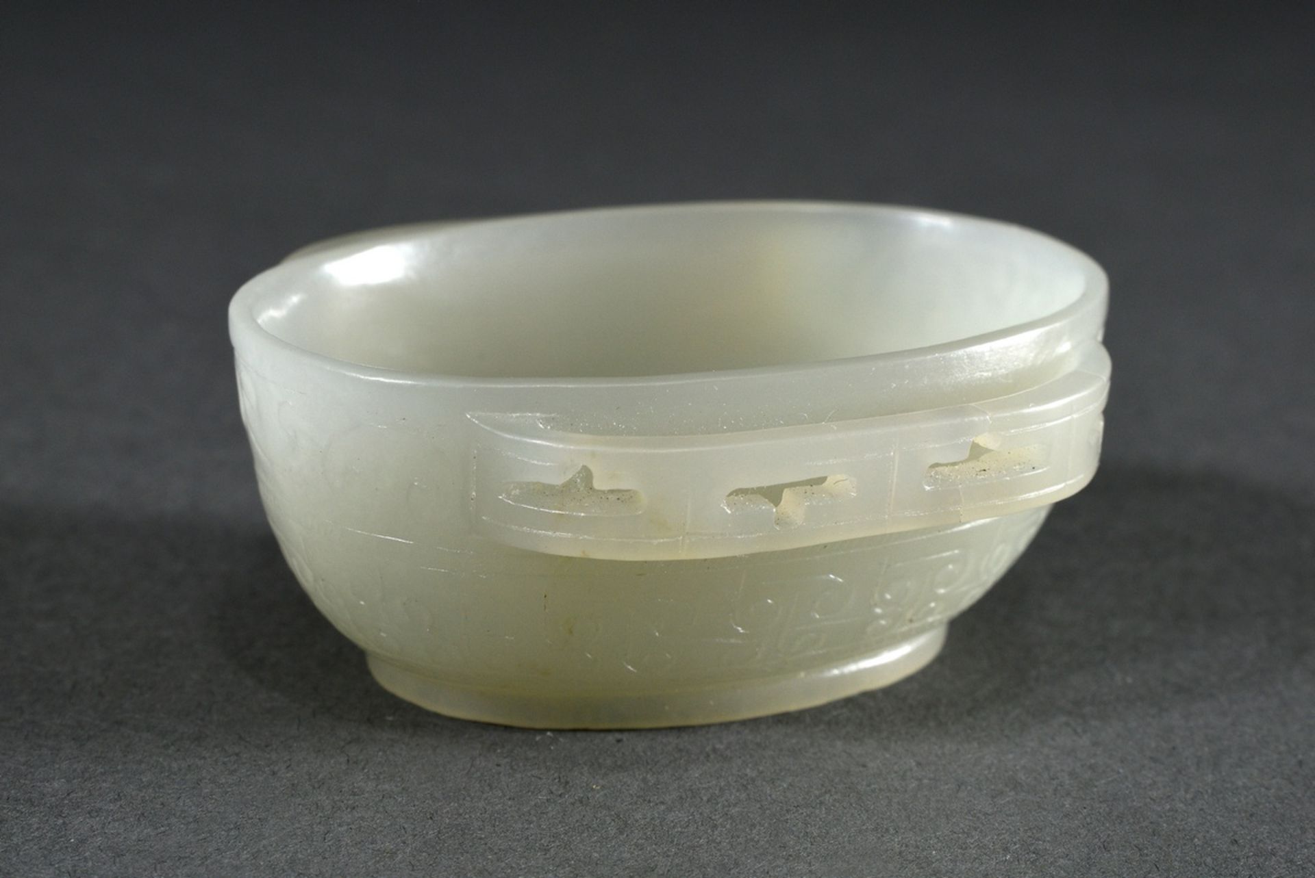 Seladon jade "ear bowl" in Han style with openwork handles and cut relief decoration in archaic sty