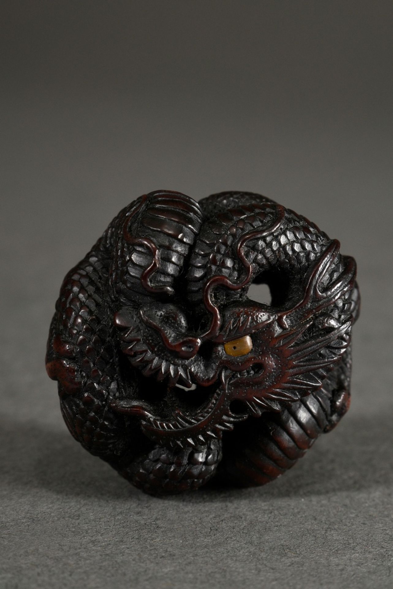 Boxwood netsuke "round laid dragon" in Manju form, inlaid eye of light horn, sign. Toyokazu, Ø 3,5c