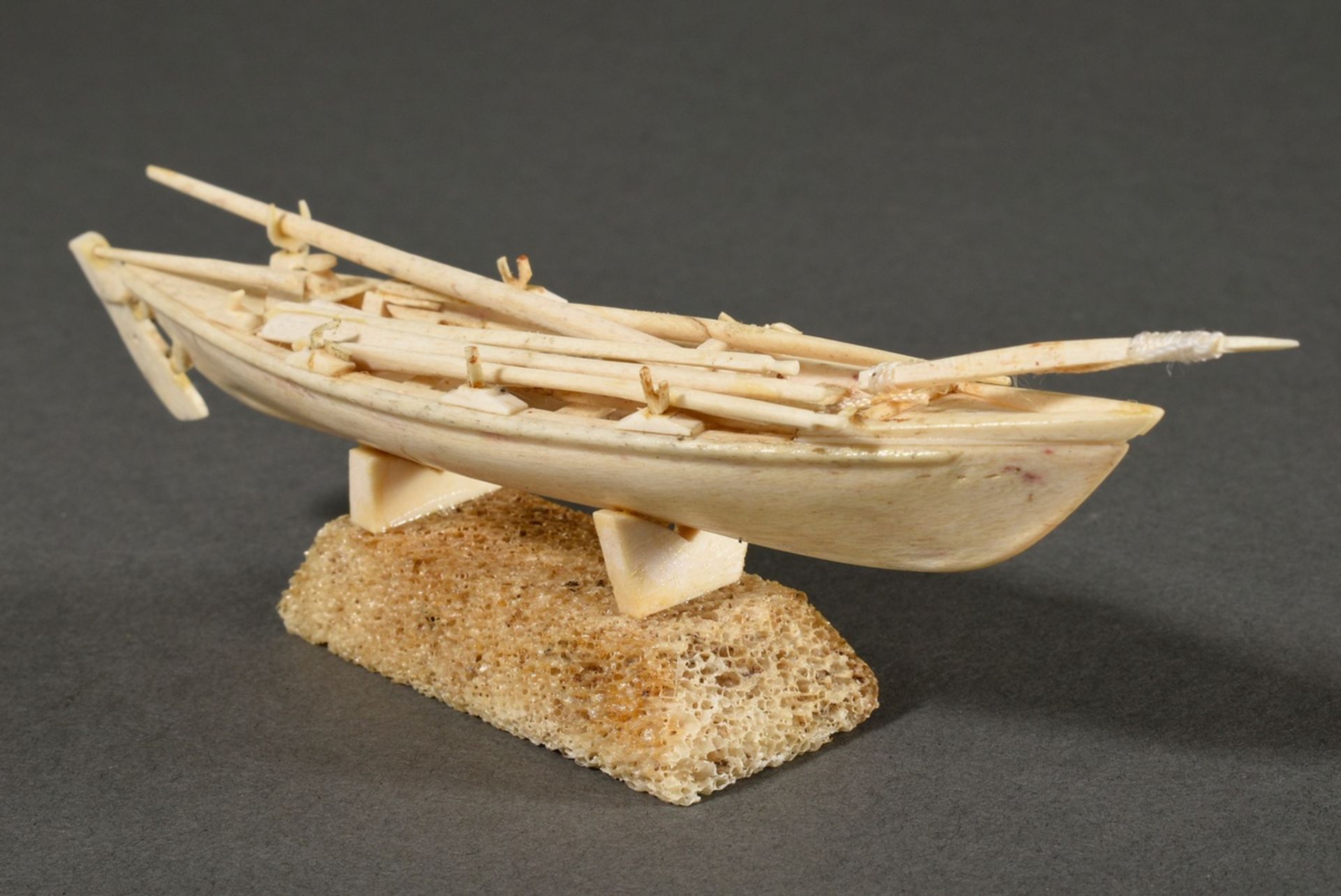 Scrimshaw "Whaling Boat", carved whale tooth, bone and thread, on base, parts partly glued, 19th c.