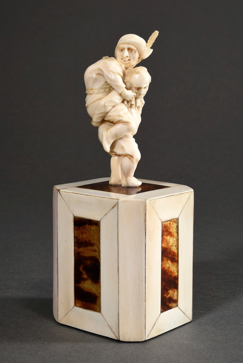 Fine ivory carving "Callot's Gnomes Piggyback" with screwable head on a high base with ivory and fo