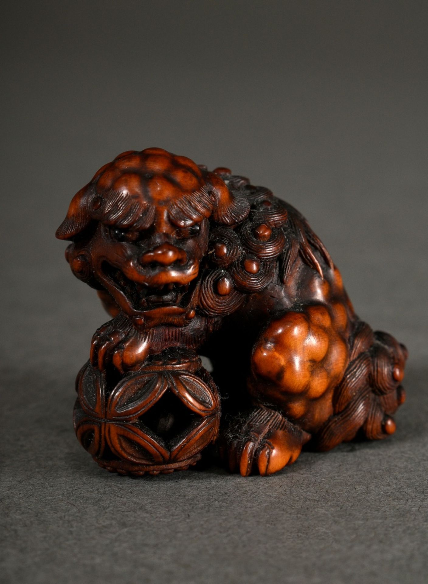 Very finely carved boxwood netsuke "Shishi with three movable balls in a basket", with eyes inlaid