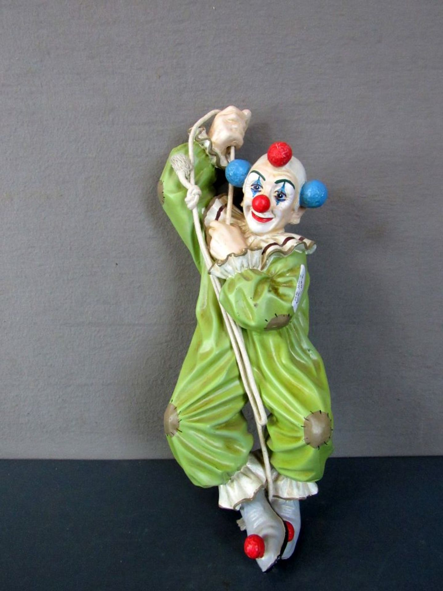 Clownfigur kletternd am Seil
