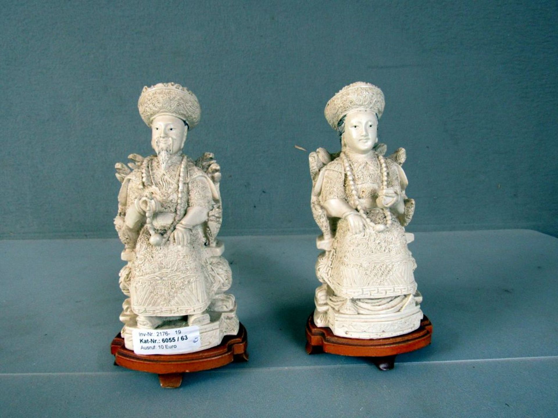 Zwei asiatische Figuren auf Holzpodest