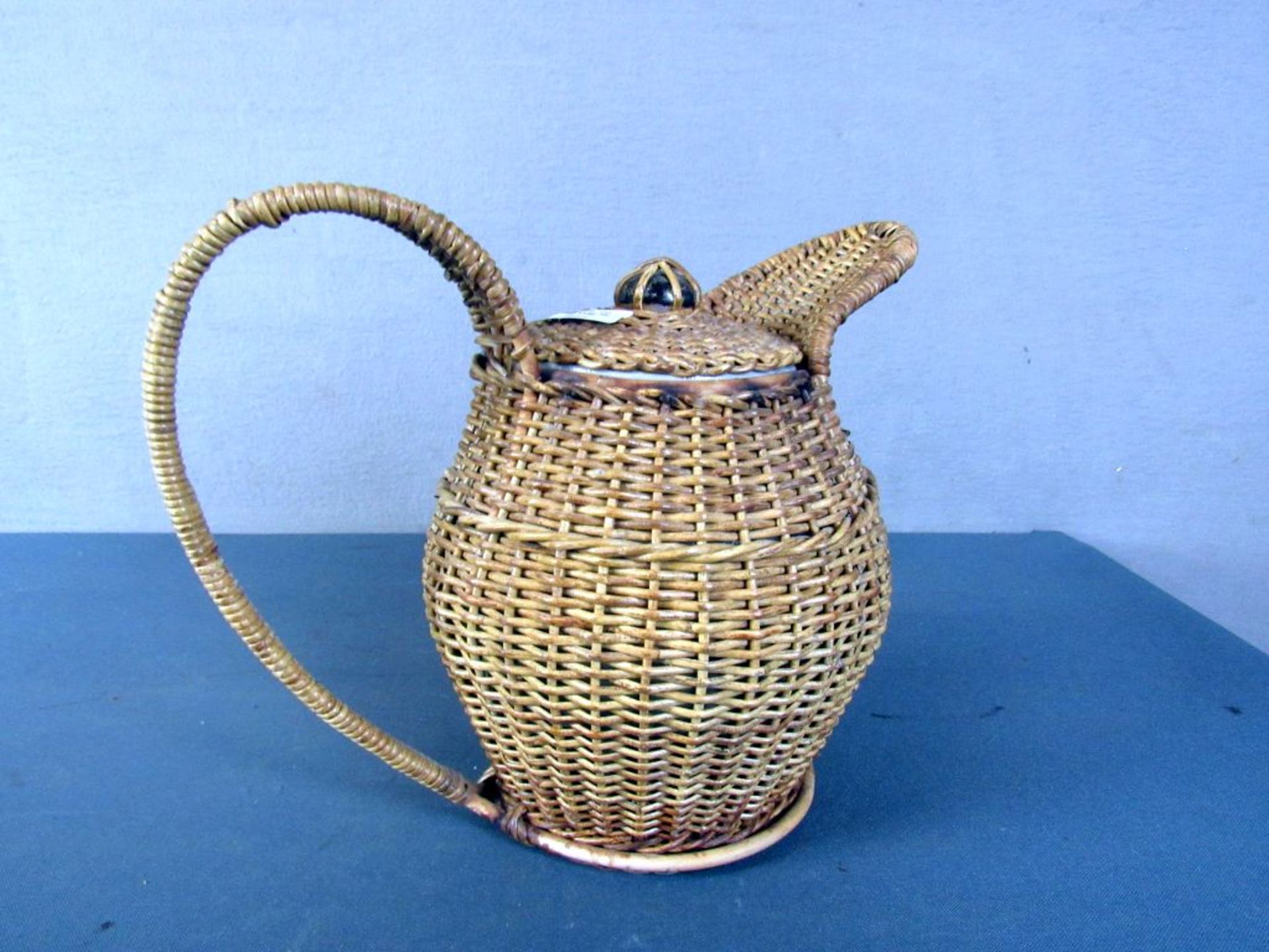 Antike Keramikkanne mit Korb bezogen