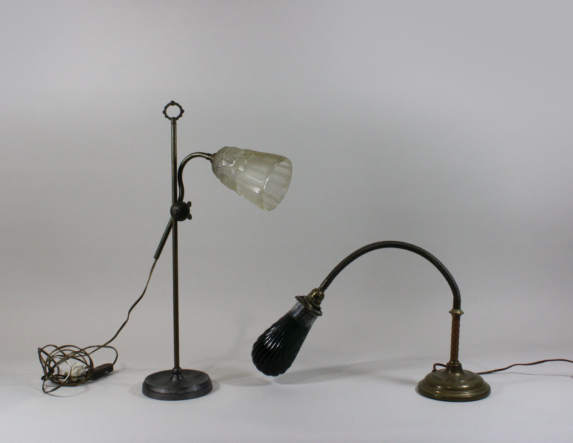 Zwei Tischlampen, Jugendstill, Frankreich, 19. Jh., Metall, mit Glashaube, H vom 60 bis 76 cm, Risse